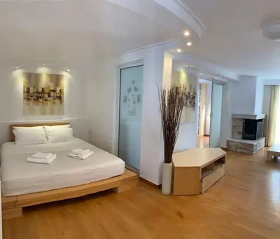 a white bedroom with a bed and a fireplace at Dafni Athens loft in Athens