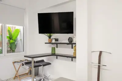 a living room with a table and a tv on a wall at Sophistic Athens in Athens