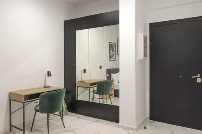 a mirror in a room with a table and chairs at Sophistic Athens in Athens