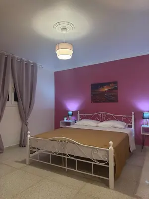 a bedroom with a large bed with purple walls at Bella's apartment in Athens