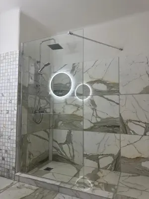 a bathroom with a shower with a glass wall at Bella's apartment in Athens