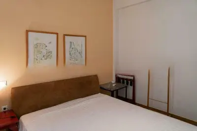 a bedroom with a bed and two pictures on the wall at Premium Plaka Apartment in Historic Athens City in Athens