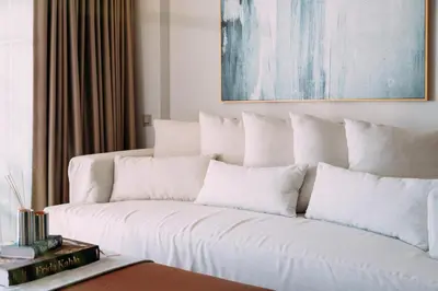 a living room with a white couch with pillows at 1BD SV Beach Condo with Pool in Athens