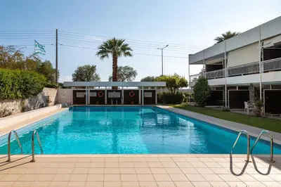 a swimming pool in front of a building at 1BD SV Beach Condo with Pool in Athens
