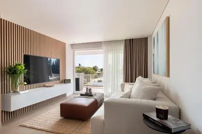 a living room with a white couch and a tv at 1BD SV Beach Condo with Pool in Athens