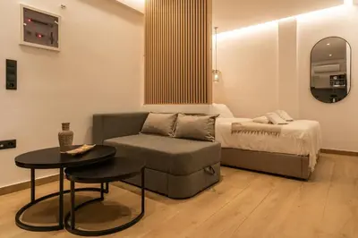 a bedroom with a bed and a chair and a table at Mini Sinatra Suite Syntagma in Athens