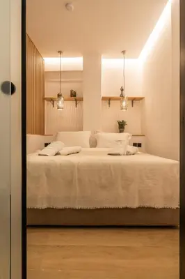 a bedroom with a large white bed with two lights at Mini Sinatra Suite Syntagma in Athens