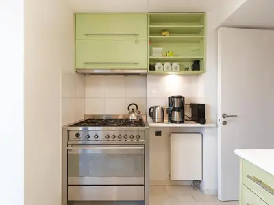 a kitchen with a stove and green cabinets at AthensView Bird's Eye Penthouse with Acropolis view -ONE BEDROOM FLAT in Athens
