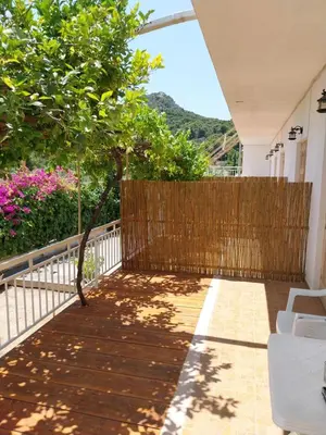 a balcony with a fence and a tree at George Apartments in Aegina Town