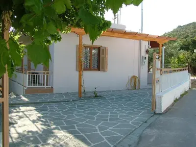 a small white house with a wooden pergola at George Apartments in Aegina Town