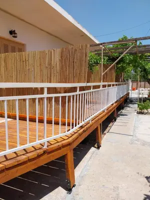 a wooden bench in front of a fence at George Apartments in Aegina Town