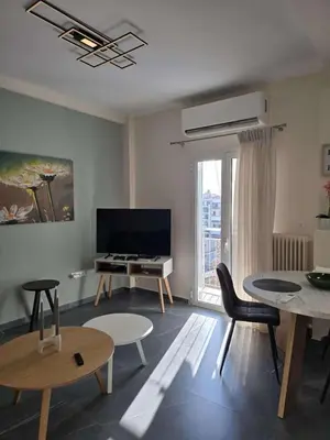 a living room with a television and a table and chairs at Nektaria philoxenia place in Athens