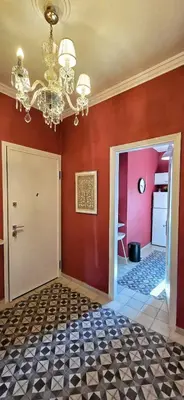 a room with red walls and a chandelier at Cozy Near Acropolis by LV in Athens