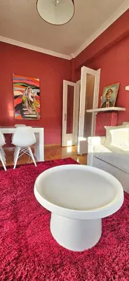a living room with a red wall and a white table at Cozy Near Acropolis by LV in Athens