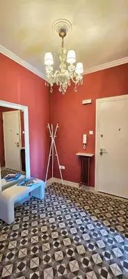 a room with a red wall with a bed and a chandelier at Cozy Near Acropolis by LV in Athens