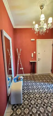 a room with a red wall with a chandelier at Cozy Near Acropolis by LV in Athens