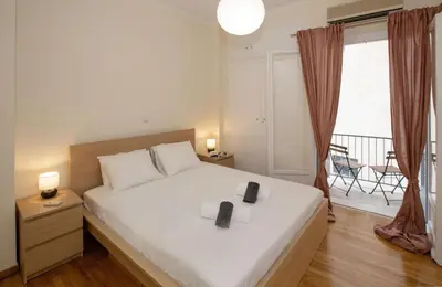 a bedroom with a large white bed and a balcony at Modern Rental with Cozy Charm by GHH in Athens