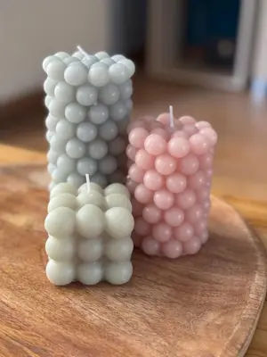 two candles sitting on top of a wooden cutting board at LoftLiving cozy in Athens