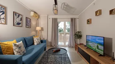 a living room with a blue couch and a tv at Central Apartment Near Acropoli in Athens