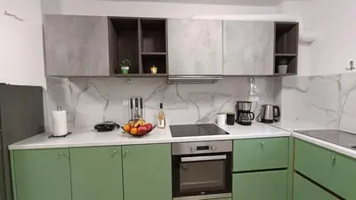 a kitchen with green cabinets and a bowl of fruit on the counter at Central Apartment Near Acropoli in Athens