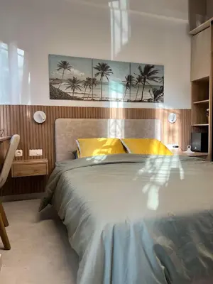 a bedroom with a large bed with palm trees on the wall at Stylish & Cozy 1 BR in Lycabetus in Athens