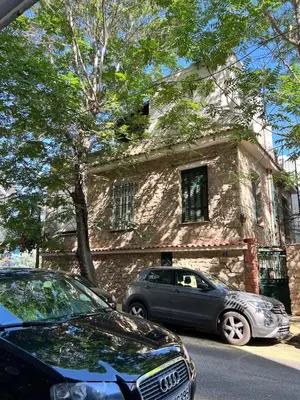 two cars parked in front of a stone house at Stylish & Cozy 1 BR in Lycabetus in Athens