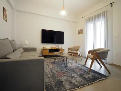 a living room with a couch and a flat screen tv at The Gallery in Athens