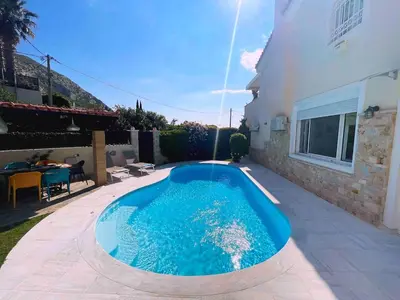 a swimming pool in a yard next to a house at Blue Paradise Seaview villa with private pool in Sounio