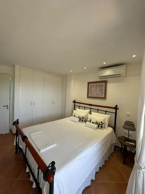 a bedroom with a large bed with white sheets at Blue Paradise Seaview villa with private pool in Sounio
