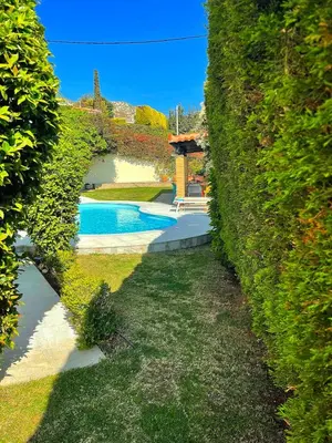 a hedge around a swimming pool in a yard at Blue Paradise Seaview villa with private pool in Sounio