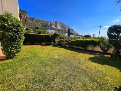 a yard with flowers and a mountain in the background at Blue Paradise Seaview villa with private pool in Sounio
