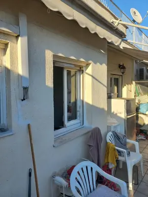 a house with two chairs and a window at هلال in Athens