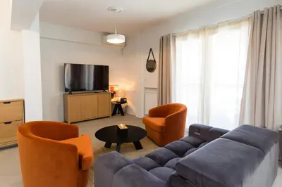 a living room with a couch and two chairs and a tv at Horizon Haven in Athens