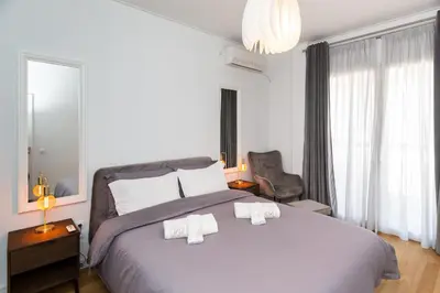 a bedroom with a large bed with two towels on it at Horizon Haven in Athens
