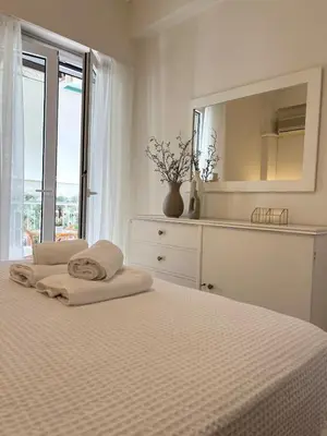 a white bedroom with a bed and a mirror at Emerald Lake Loft in Athens