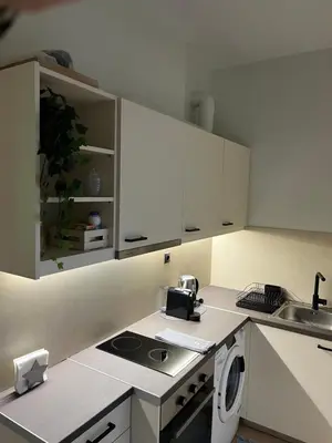 a kitchen with white cabinets and a sink at cozy smart house in Athens