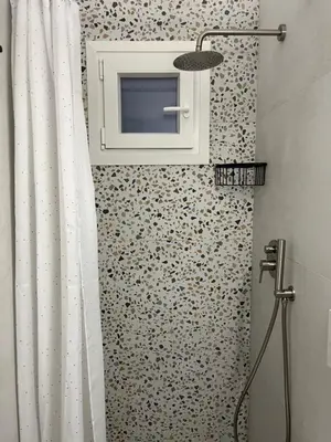 a bathroom with a shower curtain and a microwave at cozy smart house in Athens