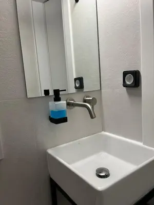 a white sink in a bathroom with a mirror at cozy smart house in Athens