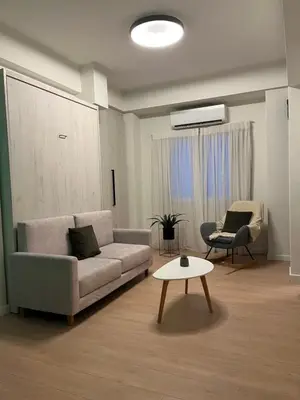 a living room with a couch and a table at cozy smart house in Athens