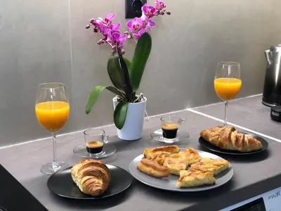 a table with two plates of food and two glasses of orange juice at cozy smart house in Athens