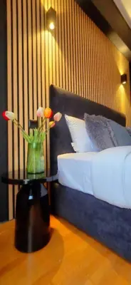 a bedroom with a bed with a vase of flowers on a table at Near Acropolis by LV in Athens