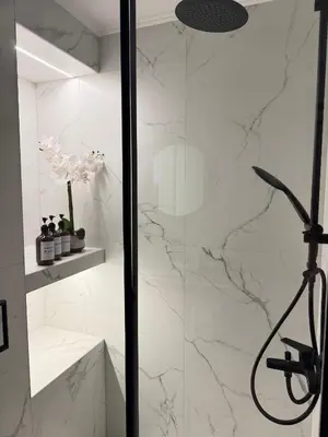 a bathroom with a shower with white marble walls at City Vibes Athens in Athens