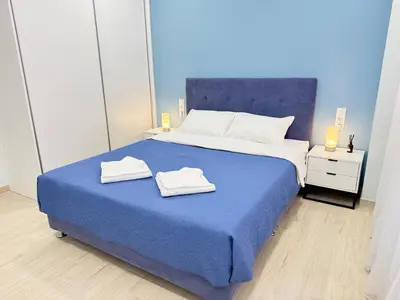 a bedroom with a blue bed with towels on it at City Vibes Athens in Athens