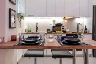 a kitchen with a wooden table with black plates on it at Modern Stay in Athens Center in Athens