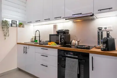 a kitchen with white cabinets and a counter top at Modern Stay in Athens Center in Athens