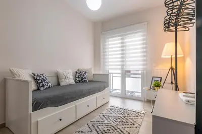 a white bedroom with a bed with a window at Modern Stay in Athens Center in Athens