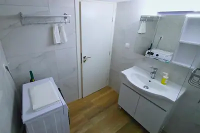 a white bathroom with a sink and a mirror at Cozy Central Stay in Athens