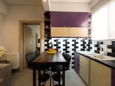a kitchen with a wooden table and purple cabinets at Athens Neos Kosmos 2BDR apt next to metro station in Athens