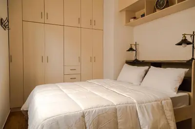 a bedroom with a white bed with white cabinets at Athens Neos Kosmos 2BDR apt next to metro station in Athens