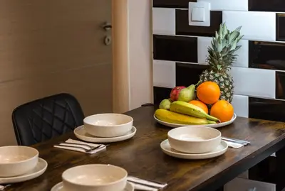 a wooden table with a plate of fruit on it at Athens Neos Kosmos 2BDR apt next to metro station in Athens